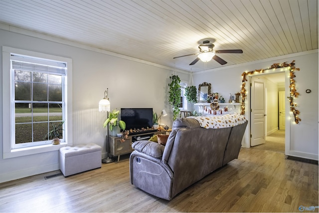 living area featuring visible vents, ornamental molding, ceiling fan, wood finished floors, and wooden ceiling