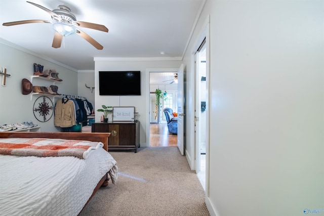 bedroom with ornamental molding, light carpet, baseboards, and a ceiling fan