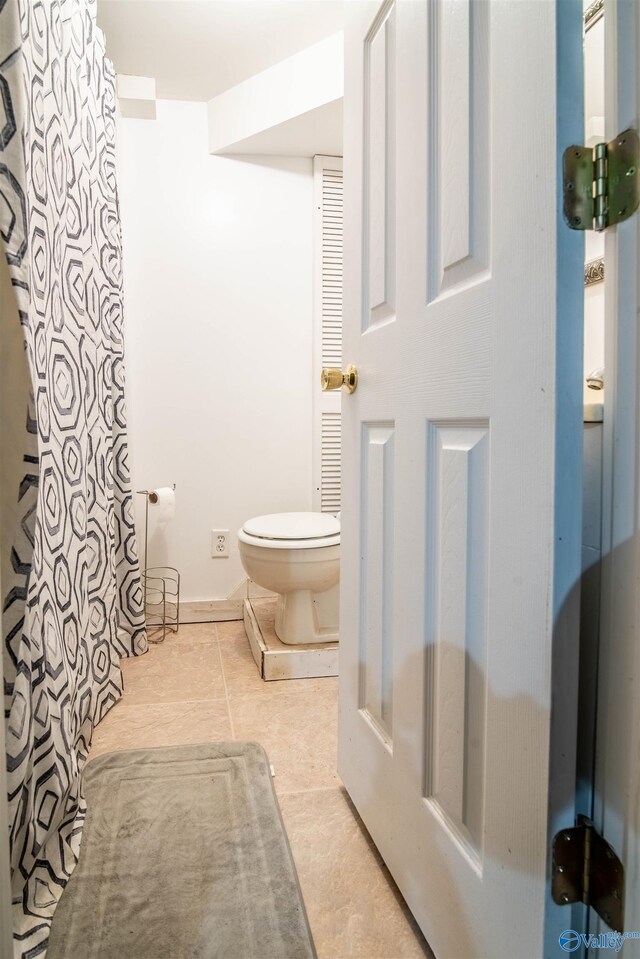 full bath featuring tile patterned flooring and toilet