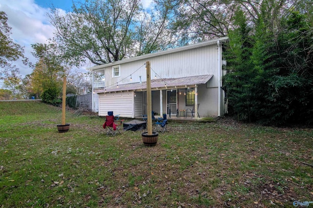 back of house featuring a patio area and a yard