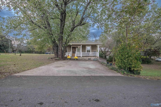 view of front of property with driveway, covered porch, and a front yard