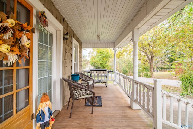 wooden terrace featuring covered porch and grilling area