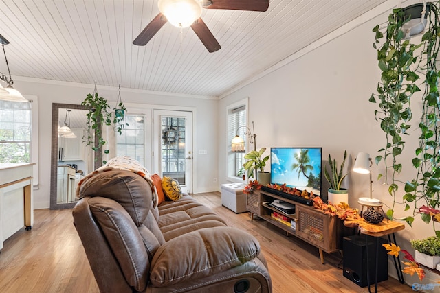 living area with baseboards, a ceiling fan, wooden ceiling, crown molding, and light wood-type flooring