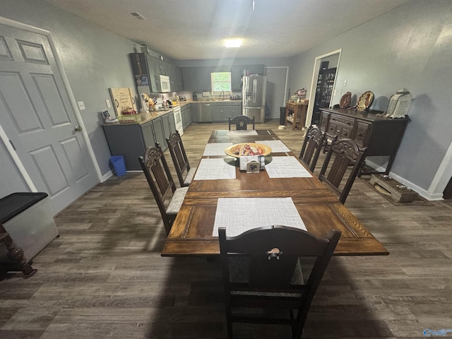 dining area with baseboards, visible vents, and wood finished floors