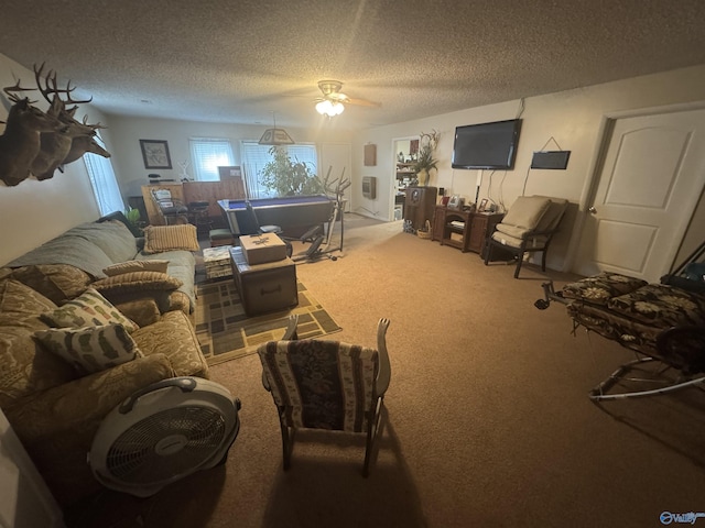 living area with a textured ceiling, carpet flooring, and a ceiling fan