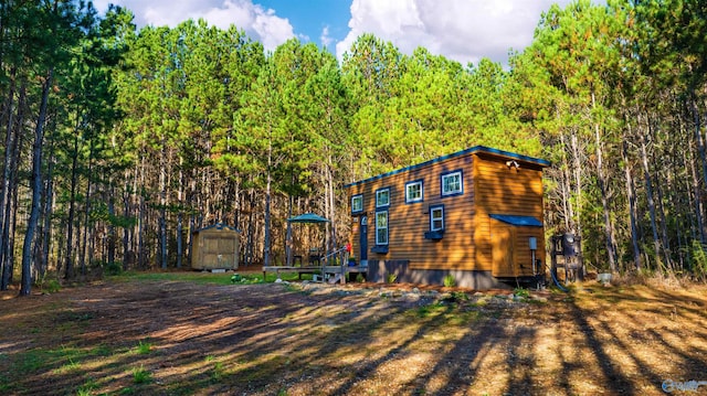 rear view of house with a storage unit