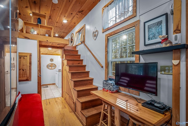 stairs with wood ceiling and hardwood / wood-style flooring