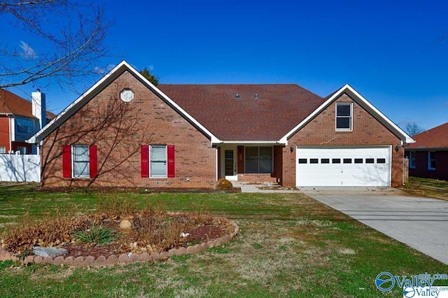 view of front of home featuring driveway, a garage, brick siding, fence, and a front yard