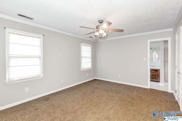 empty room featuring a textured ceiling, ceiling fan, carpet flooring, visible vents, and ornamental molding