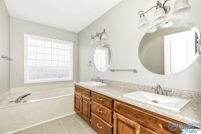 bathroom with double vanity, a garden tub, a sink, and tile patterned floors