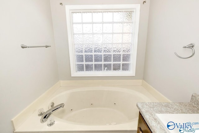 bathroom with a jetted tub and vanity