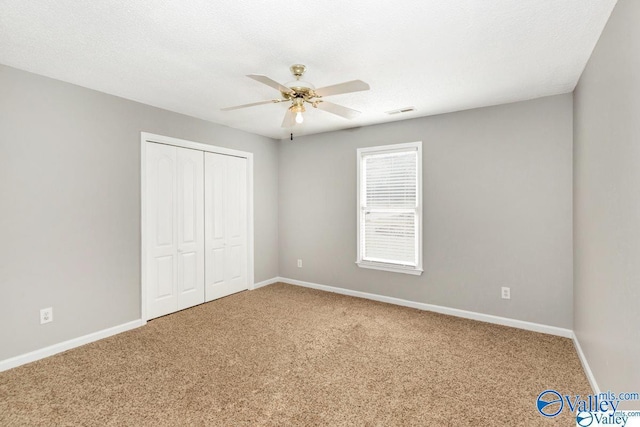 unfurnished bedroom with carpet floors, a closet, visible vents, and baseboards