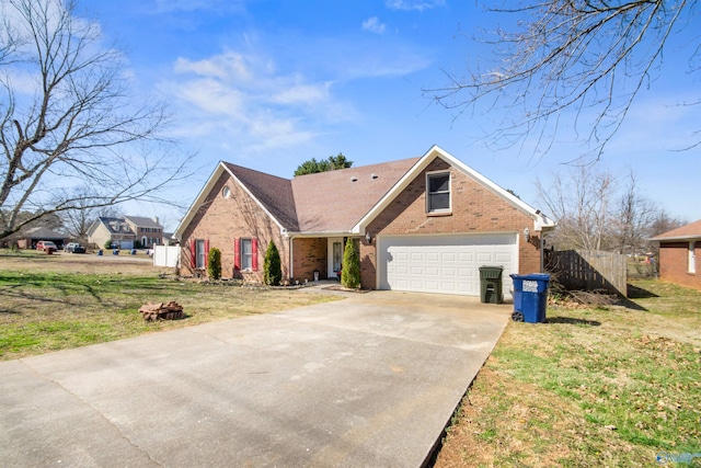 view of front of house featuring a garage, concrete driveway, fence, a front lawn, and brick siding