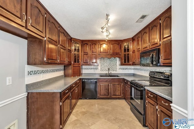 kitchen featuring black appliances, glass insert cabinets, a sink, and visible vents