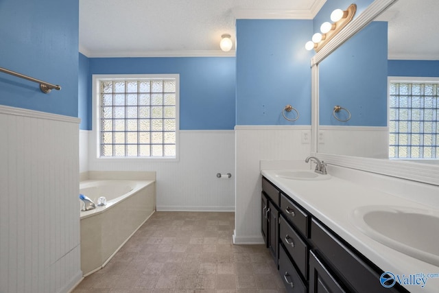 bathroom featuring a bathing tub, vanity, crown molding, and a textured ceiling