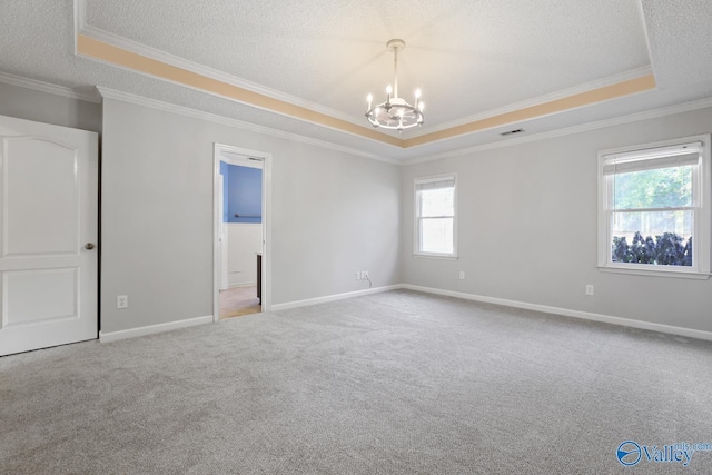 carpeted empty room featuring plenty of natural light, a raised ceiling, crown molding, and an inviting chandelier