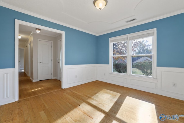 spare room featuring hardwood / wood-style flooring and ornamental molding