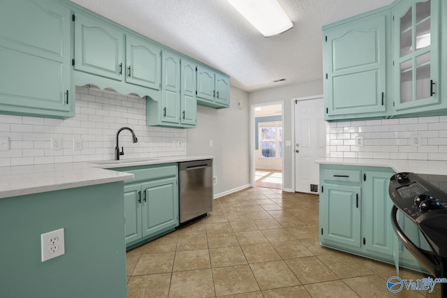 kitchen featuring backsplash, sink, stainless steel dishwasher, a textured ceiling, and light tile patterned flooring