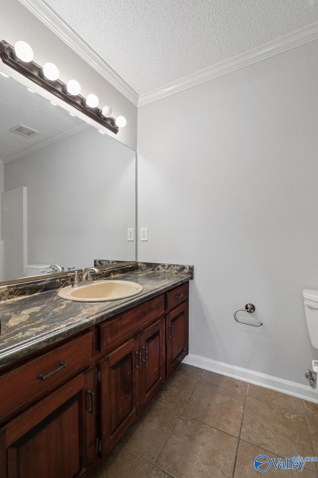 bathroom featuring tile patterned flooring, crown molding, a textured ceiling, toilet, and vanity