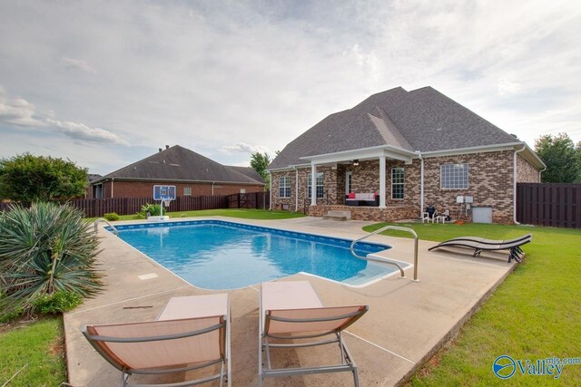 view of swimming pool featuring a lawn and a patio