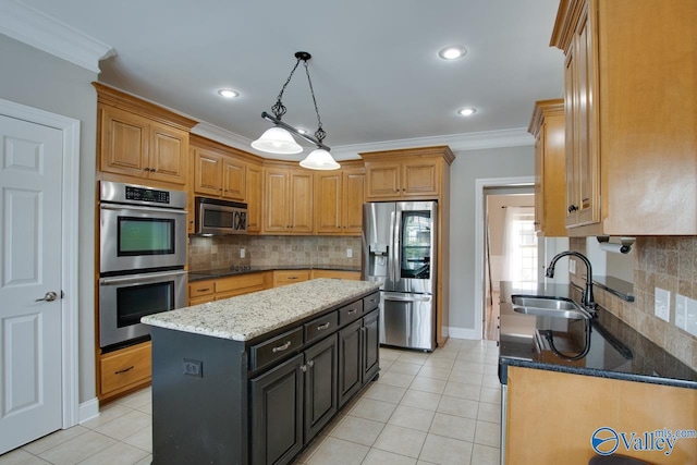 kitchen with light stone counters, sink, stainless steel appliances, a center island, and crown molding