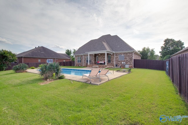 view of pool featuring a lawn and a patio