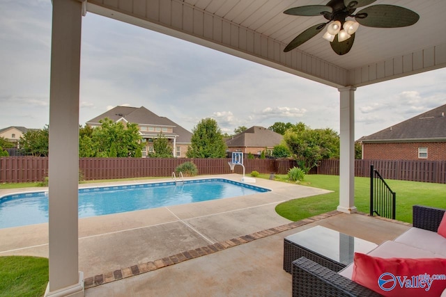 view of swimming pool with ceiling fan, a yard, and a patio