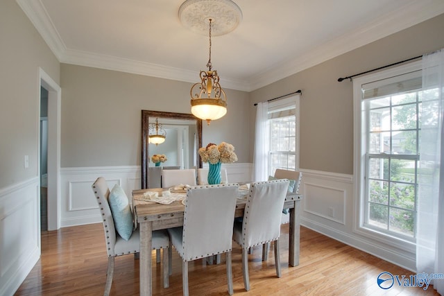 dining area with a healthy amount of sunlight, crown molding, and light hardwood / wood-style flooring