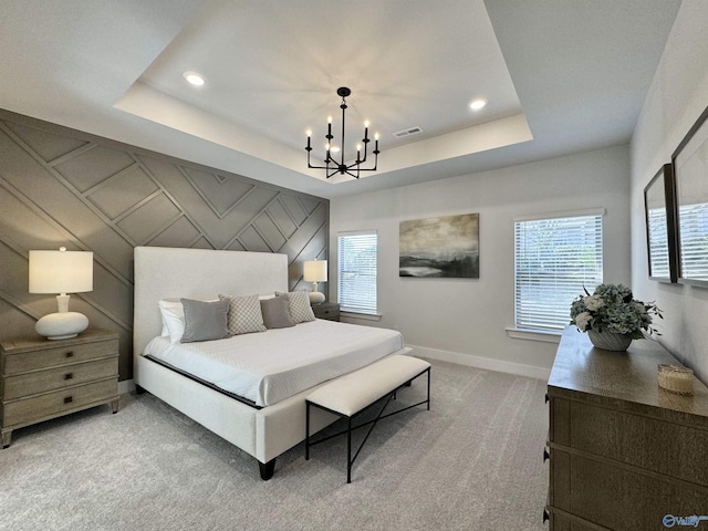 bedroom with a tray ceiling, light colored carpet, and a notable chandelier