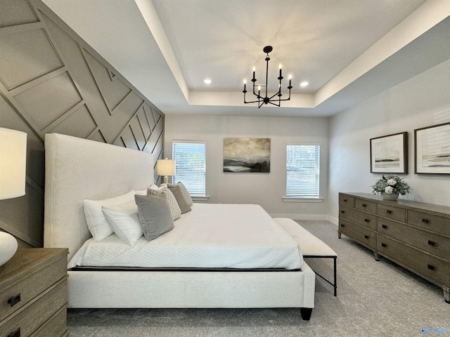 bedroom featuring light carpet, an inviting chandelier, and a raised ceiling