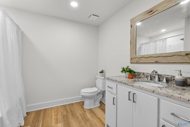 bathroom with hardwood / wood-style floors, vanity, and toilet