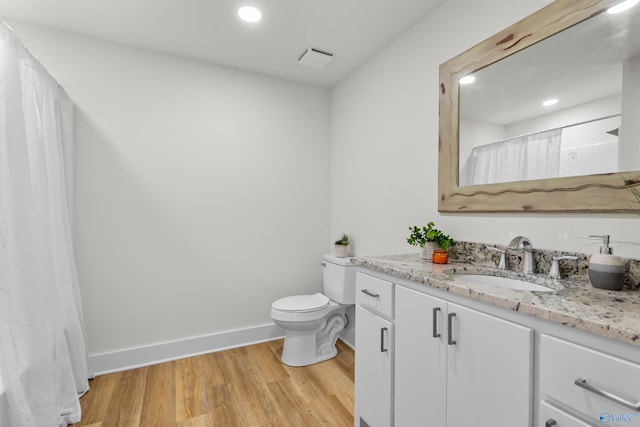 bathroom with vanity, toilet, and wood-type flooring