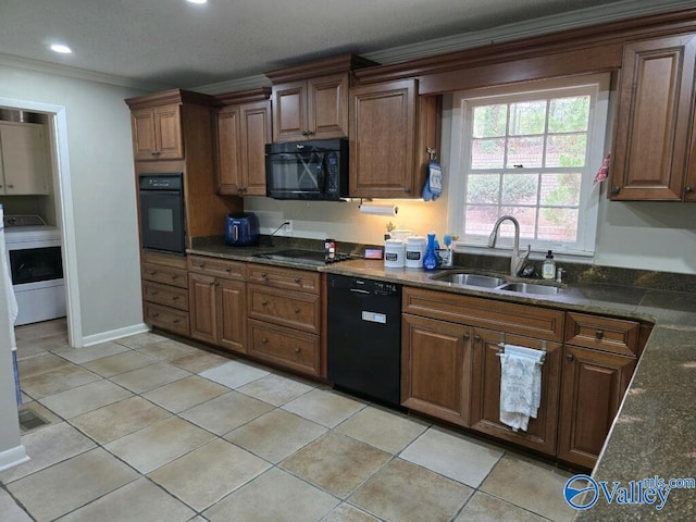 kitchen featuring dark stone counters, black appliances, light tile patterned flooring, and sink