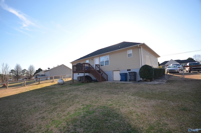 rear view of house with a garage, stairs, a gate, fence, and a yard