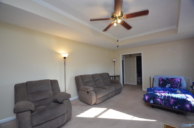 living area with ornamental molding, a raised ceiling, carpet flooring, and baseboards