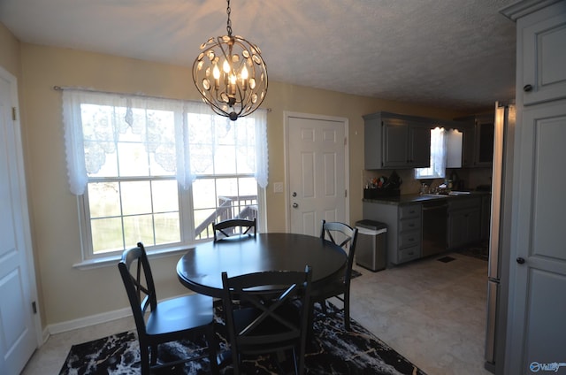 dining area with a notable chandelier, a textured ceiling, and baseboards