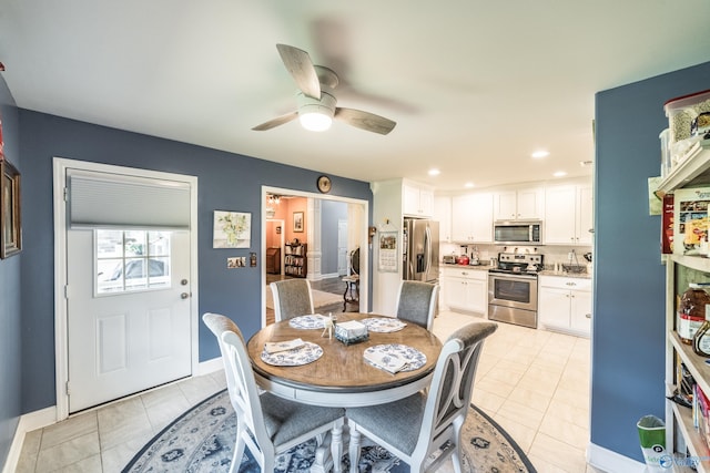 dining space with light tile patterned flooring, ceiling fan, and baseboards