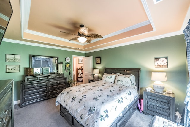 bedroom with carpet floors, ornamental molding, a raised ceiling, and a ceiling fan