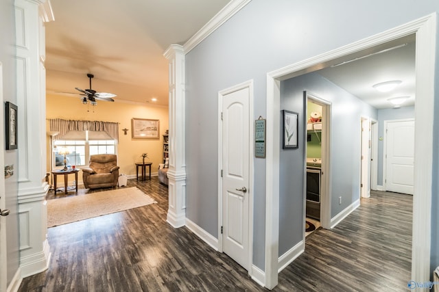 corridor with crown molding, baseboards, decorative columns, and dark wood-style floors
