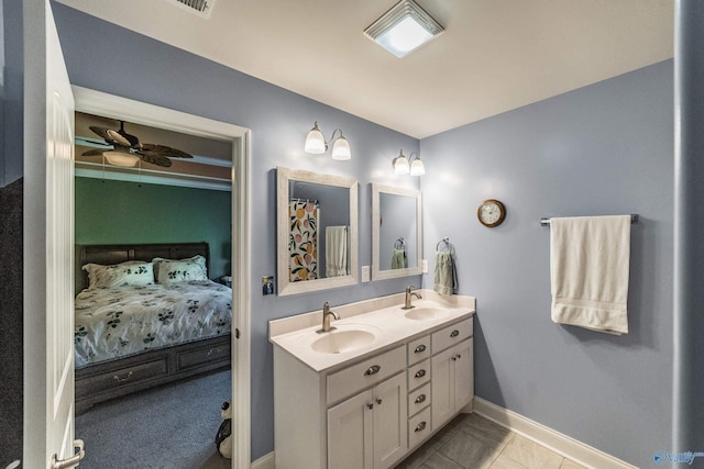 ensuite bathroom with ensuite bathroom, a sink, baseboards, and a ceiling fan