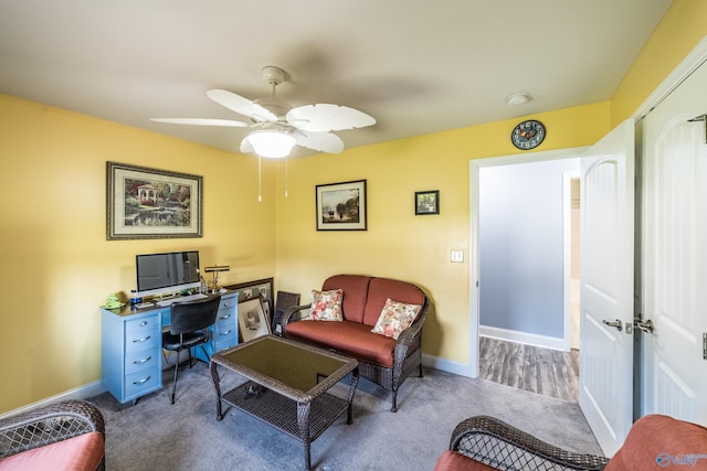 carpeted home office with baseboards and ceiling fan