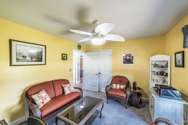 living room with a ceiling fan, baseboards, and carpet