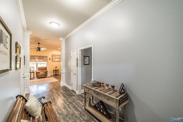 corridor featuring baseboards, ornamental molding, ornate columns, and wood finished floors