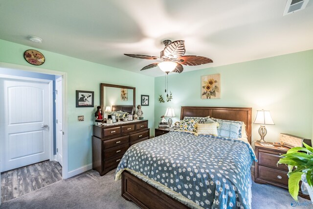 carpeted bedroom featuring ceiling fan, visible vents, and baseboards