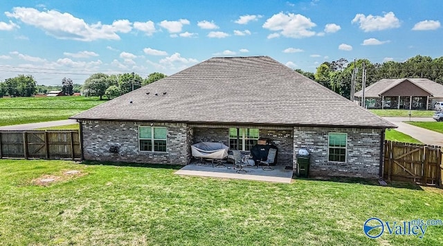 rear view of house featuring brick siding, a fenced backyard, and a patio area