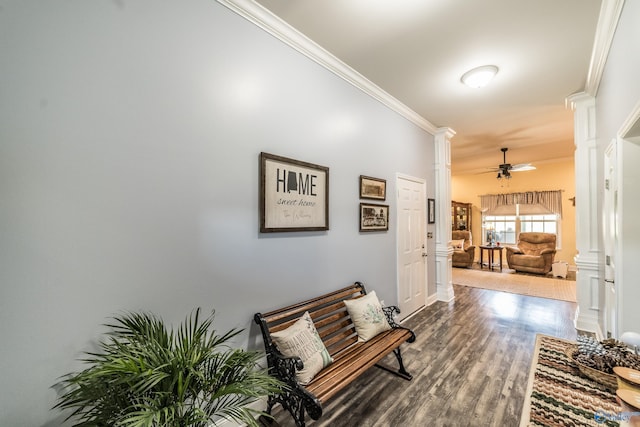 corridor with crown molding, ornate columns, and wood finished floors