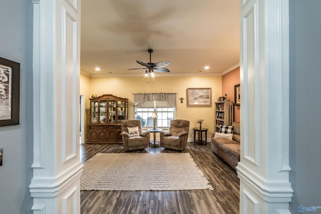 living area with a ceiling fan, baseboards, dark wood-style floors, and ornamental molding
