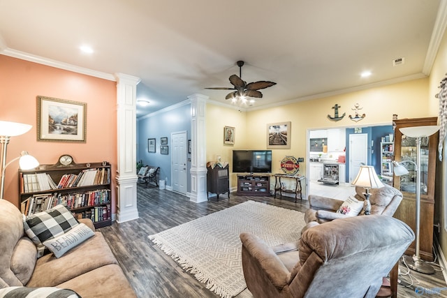 living area with crown molding, a ceiling fan, wood finished floors, ornate columns, and visible vents