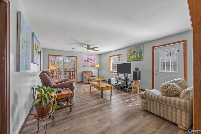 living room featuring ceiling fan, wood finished floors, and baseboards