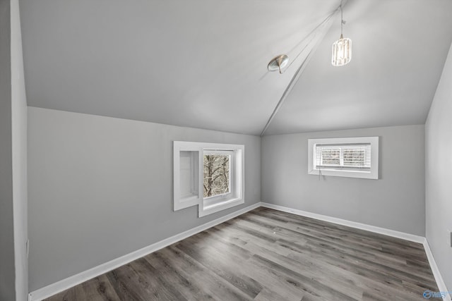 bonus room with lofted ceiling, baseboards, and wood finished floors